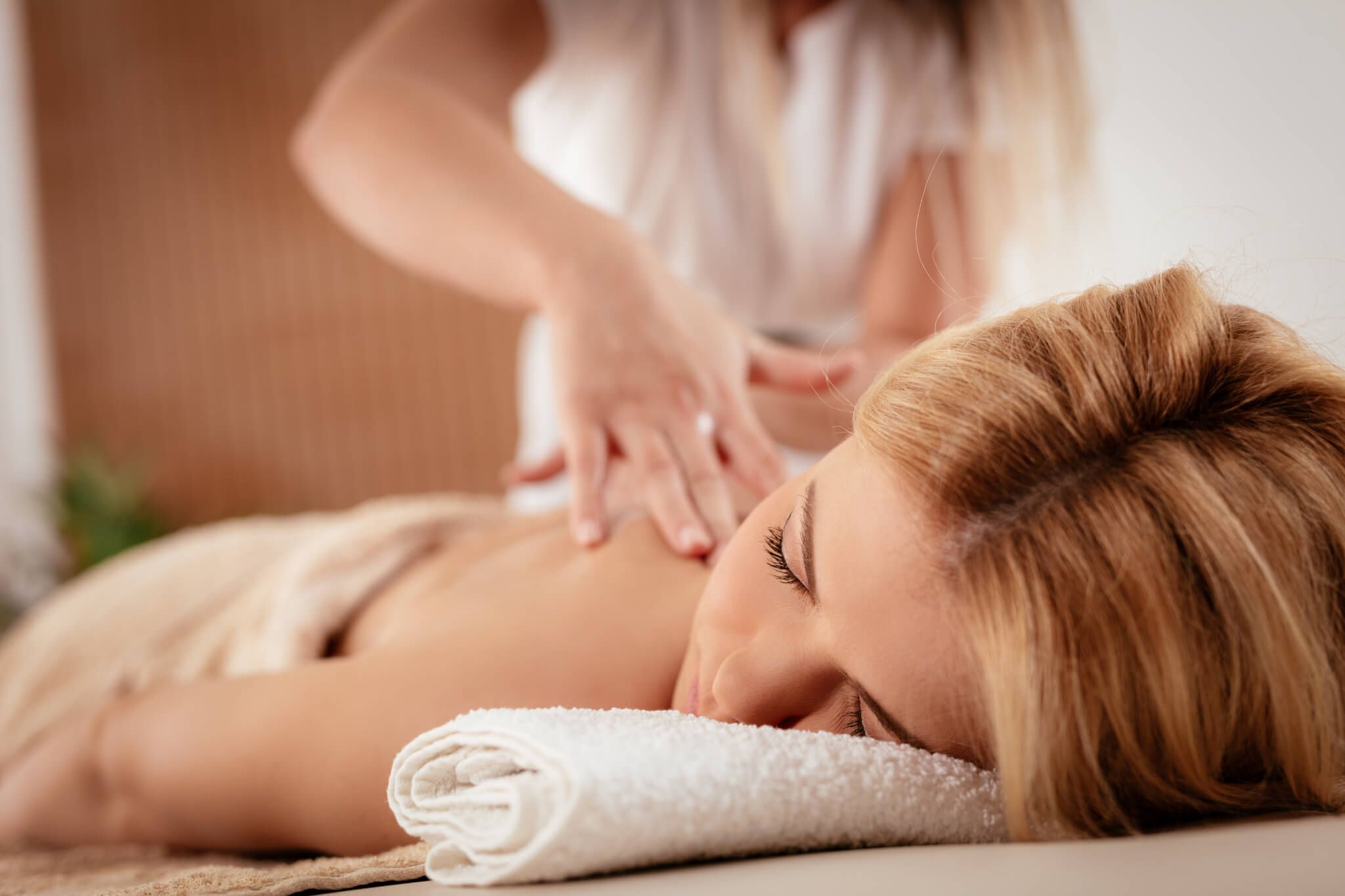 A female massage therapist giving a massage to a female client.